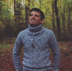 Portrait of smiling man in forest during autumn