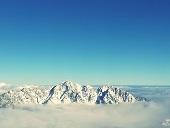 Scenic view of snowcapped mountains against clear blue sky