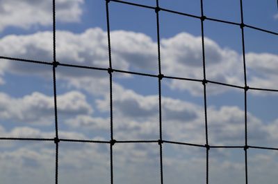 Low angle view of cloudy sky seen through netting