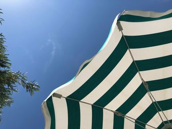 Low angle view of parasol against blue sky