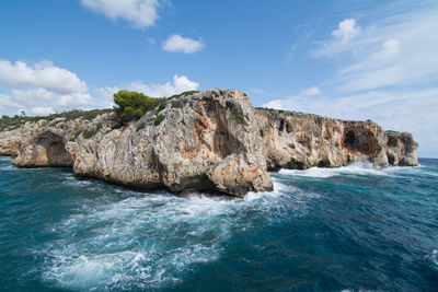 Rock formations by sea against sky