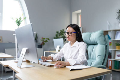 Businesswoman using laptop while sitting on table