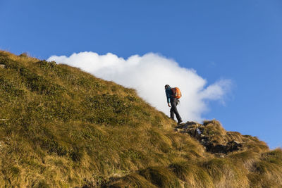 Man standing by mountain against sky