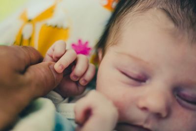 Close-up of baby girl sleeping on bed