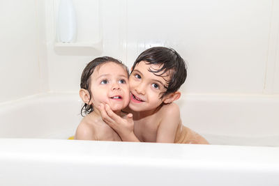 Two young boy brothers having fun in a bathtub