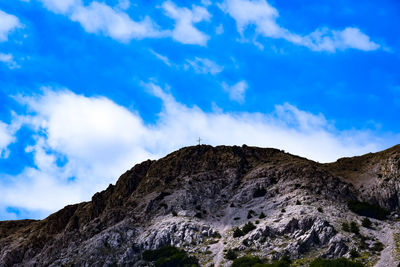 Low angle view of mountain against blue sky