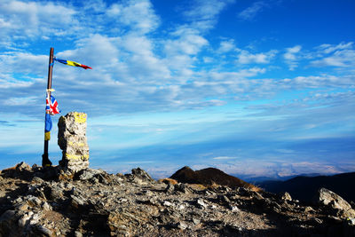 View of flag on mountain against blue sky