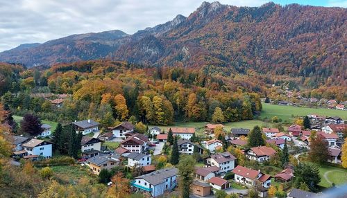 High angle view of townscape by trees and houses against sky