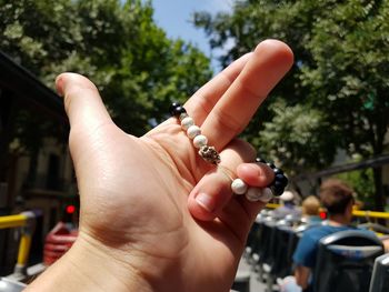 Cropped hand of girl holding bracelet