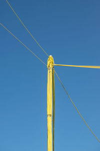 Low angle view of windmill against clear blue sky