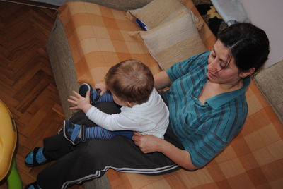 High angle view of friends sitting on wooden floor