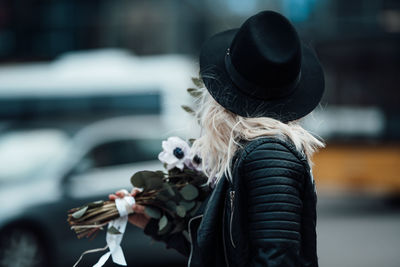 Rear view of woman wearing hat standing outdoors