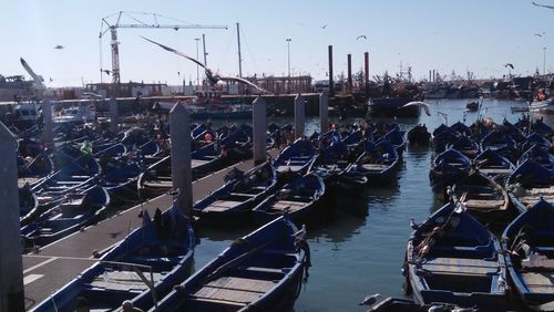 Boats moored at harbor in city