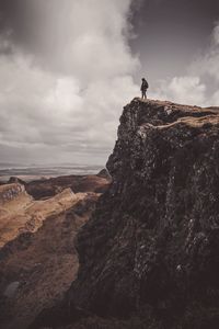 Man standing on cliff against sky