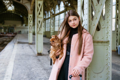 Young girl in pink coat at train station. beautiful woman stands on platform