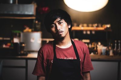 Portrait of young man standing in restaurant