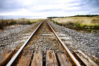 Railroad track amidst landscape against sky