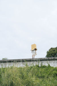 Person standing on field against sky