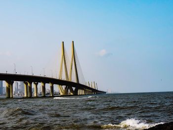 Bridge over sea against clear sky