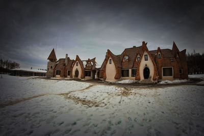 Houses in winter season against sky