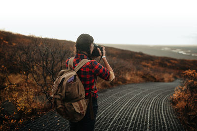 Rear view of man photographing