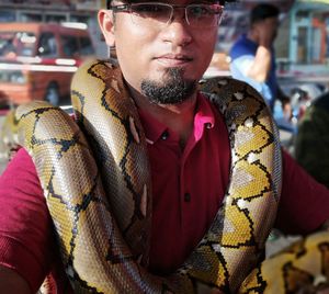 Close-up portrait of man with snake