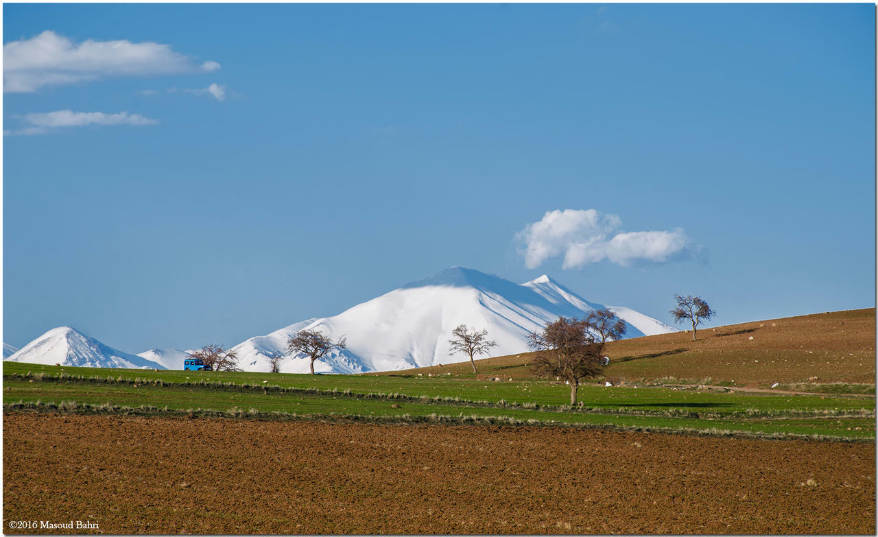 landscape, field, sky, blue, rural scene, cold temperature, building exterior, mountain, snow, winter, built structure, transfer print, agriculture, nature, architecture, tranquil scene, day, farm, tranquility, cloud