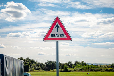 Road sign against sky