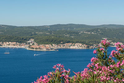 Scenic view of sea and mountains against clear blue sky