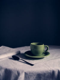 Close-up of coffee cup on table against black background