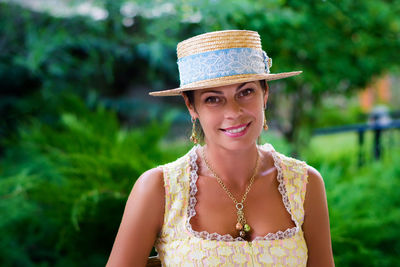 Portrait of smiling woman wearing hat in yard