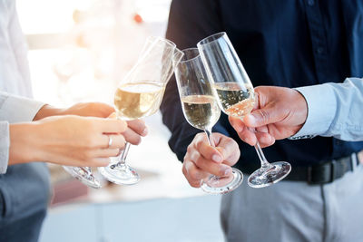 Midsection of man holding wineglass