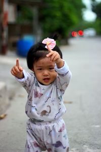 Portrait of cute girl standing on road