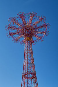 Low angle view of ferris wheel against clear blue sky