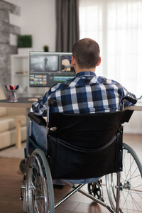 Rear view of man sitting on table