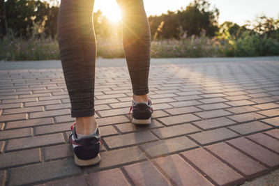 Low section of woman standing on footpath