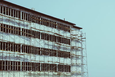 Scaffoldings on building against sky at construction site