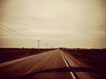 Road against sky seen through car windshield