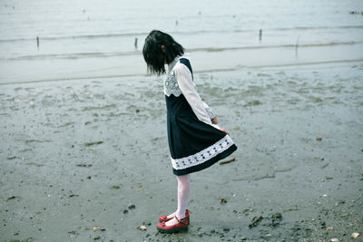 Side view of girl standing on beach