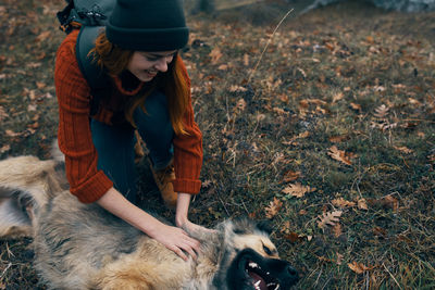 Midsection of woman with dog on field