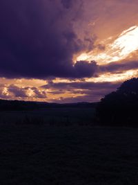 Scenic view of silhouette field against sky at sunset