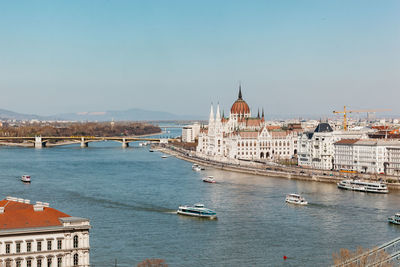 Panoramic view of buildings by river against sky in city