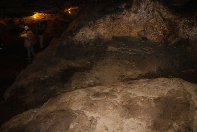 Rear view of woman standing in cave