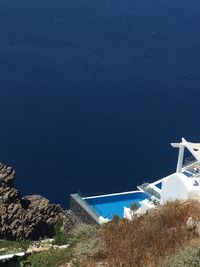 High angle view of buildings by sea against blue sky