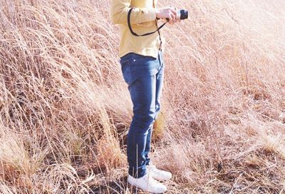 Low section of man standing on field