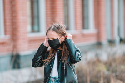 Girl wearing mask while standing outdoors