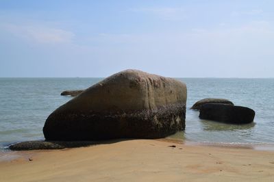 Scenic view of rocks on beach against sky