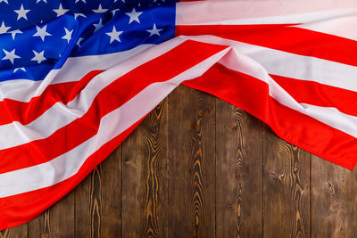 Crumpled usa flag on flat textured wooden surface background