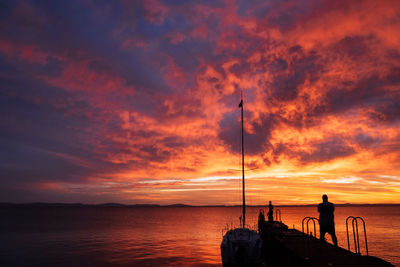 Scenic view of sea against dramatic sky during sunset