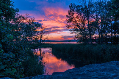 Scenic view of lake against sky at sunset